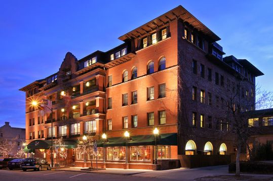 Large historic building made of red stone at night.